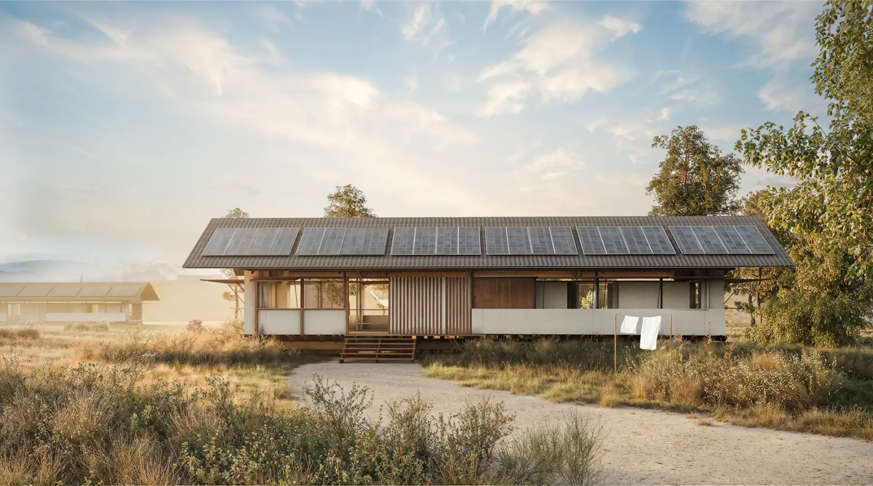 Casa térrea de campo com placas solares no telhado, cercada por vegetação seca de cerrado ao amanhecer